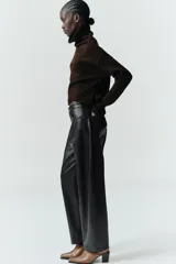 Pantalón de tiro medio con diseño tipo ballon, confeccionado en material efecto piel. Cuenta con cinco bolsillos, cierre frontal con cremallera y botón metálico.