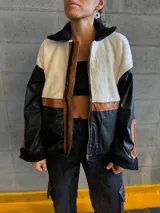 Campera negra con paneles de cuero sintético con textura de cocodrilo, corderito color crema en la parte superior y detalles en cuero marrón.
