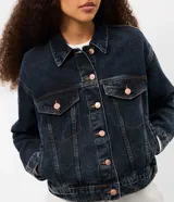 Campera de jean con corte boxy, cuello clásico, cierre frontal con botones metálicos, bolsillos con solapa en el pecho y costuras reforzadas.