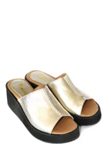 Zueco con plataforma de cuero negro con estampado croco en tonos dorados.