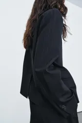 Blazer de cuello alto y manga larga con cierre frontal de botones. Presenta un diseño de raya diplomática, falsos bolsillos de vivo en el delantero y abertura en la espalda.