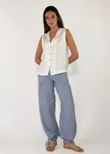 Pantalón holgado de lino color celeste, con bolsillos laterales y botamangas ajustables con tiras para fruncir.