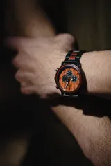 Reloj multifuncional para hombre, con caja de madera de sándalo rojo y acero inoxidable negro. La esfera es de madera de sándalo rojo con subdiales negros funcionales que ofrecen cronógrafo, indicador de 24 horas y fechador. La malla es de acero inoxidable negro con incrustaciones de madera de sándalo rojo.