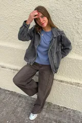 Cazadora de denim en tono gris lavado, con diseño de costuras marcadas, cuello camisero, cierre frontal con botones y bolsillos laterales.