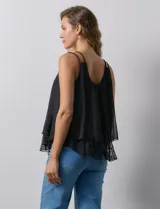 Blusa negra de gasa con breteles finos trenzados, escote redondo y capas superpuestas de encaje y gasa en el frente.
