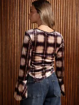 Blusa de terciopelo con estampado a cuadros, corte asimétrico y mangas largas acampanadas.