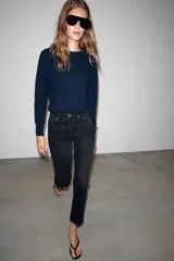 Jeans mom fit de tiro alto color negro con efecto lavado, diseño de cinco bolsillos y corte tobillero.