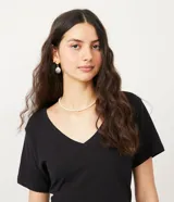 Remera básica de algodón color rosa pálido, con escote en V y mangas cortas.