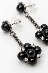 Aros colgantes oscuros con perlas negras y pequeños cristales brillantes agrupados en el extremo inferior, unidos por una cadena corta.
