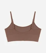 Soutien tipo top de color negro, confeccionado en tejido seamless texturizado con tirantes finos ajustables. Cuenta con copas desmontables y diseño sin costuras.