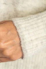 Sweater de tejido de punto color bordó, con cuello redondo, mangas largas y puños acanalados. Presenta un diseño de corte recto y textura suave.