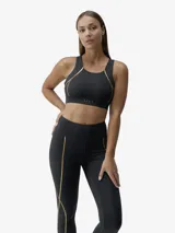 Top deportivo negro con detalles de líneas doradas termoselladas. Presenta un diseño de espalda ancha regulable, tejido compacto y ligero, y copas extraíbles.