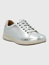 Zapatilla Hush Puppies modelo Spinal de cuero metalizado plateado, con cordones al tono, suela de goma color crema y detalle en el talón. Cuenta con tecnología Spinal para soporte y amortiguación.