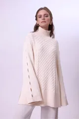 Sweater de punto color bordó con cuello alto y diseño de trenzas en el frente y las mangas. Presenta un corte holgado y largo, con puños y ruedo acanalados.