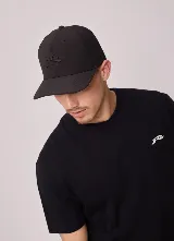 Gorro tipo gorra con visera de la marca Rusty, color negro, con el logo bordado al tono en el frente.