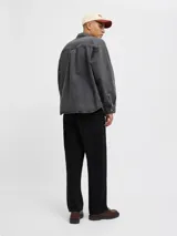 Camisa de denim negra de manga larga con cuello clásico y cierre con botones. Diseño amplio con bolsillos en el pecho.