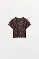 Top crop semitransparente de encaje negro, con cuello redondo y manga corta.