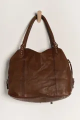 Bolso tote de cuero lavado negro con efecto gastado, interior amplio, bolsillos exteriores con cremallera, dos asas de mano y correa desmontable y regulable.