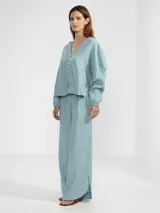 Pantalón celeste de lino italiano, de pierna ancha, con cintura elástica ajustable con cordón y bolsillos laterales.