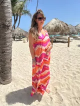 Vestido largo sin mangas de fibrana con estampado abstracto en tonos naranja, fucsia y beige.