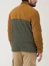 Buzo de polar con diseño color block en tonos tostado y verde oliva. Presenta cuello alto con cierre medio, bolsillo frontal con cierre y parche decorativo con logo de la marca.
