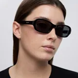 Lentes de sol con montura rectangular de bordes redondeados en color negro brillante. Cuentan con lentes polarizadas oscuras con protección UV400.