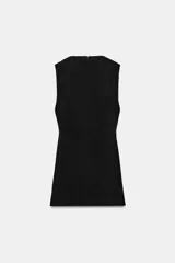 Vestido corto negro de cuello perkins, sin mangas y corte recto, con cierre posterior de cremallera oculta.