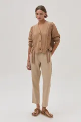 Conjunto color beige compuesto por un top sin mangas y un pantalón chino de lino metalizado, con tiro medio-alto, pierna recta, bolsillos laterales y traseros.