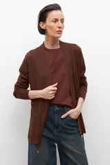 Ruana de tejido de punto color marrón chocolate, con cuello en V y diseño abierto, sin mangas.