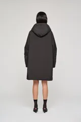 Campera reversible de corte regular, confeccionada en nylon con acabado repelente al agua. Presenta diseño con capucha, mangas raglán y cierre frontal con botones. Un lado es de color negro con bolsillos de parche, mientras que el reverso es de color plateado con bolsillos laterales integrados.