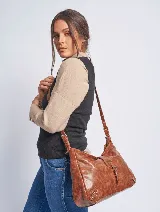 Cartera negra de cuero sintético con asa al hombro regulable y cierre con broche imantado.