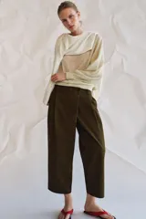 Pantalón cropped de tiro medio con diseño de pinzas en el delantero, trabillas para cinturón, bolsillos laterales y bolsillos de vivo en la parte trasera. Cierre frontal con cremallera y botón.