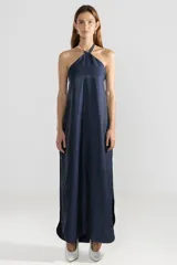 Vestido largo azul marino con escote halter y espalda descubierta. Confeccionado en lino italiano con hilo metalizado.