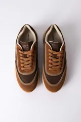 Championes urbanos Urban Haus modelo Julen, con diseño de paneles en tonos verde oliva y beige. Presentan una combinación de texturas en gamuza y material sintético, con suela de goma dentada en color caramelo.