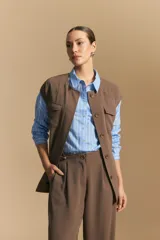 Camisa de manga larga a rayas verticales blancas y azules, con cuello camisero, cartera frontal con botones y calce relajado.