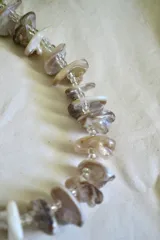 Collar corto con cuentas irregulares de nácar y mostacillas transparentes. Cierre con cadena de acero quirúrgico y ganchito para regular el largo.