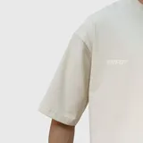 Remera de corte oversize color beige, con diseño estampado en la espalda que incluye el texto VNFO y leyendas adicionales.