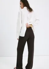 Pantalón negro de silueta recta, corte largo y tiro medio, confeccionado en mezcla de algodón y poliéster.