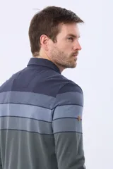 Remera polo de manga larga con diseño rayado en degradado de tonos azules y grises, cuello liso azul marino y logo bordado en el pecho. Confeccionada en tejido piqué de algodón.