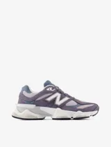 Championes urbanos New Balance serie 9060, con diseño robusto en tonos gris y violeta. Confeccionados en una combinación de gamuza, malla y materiales sintéticos. Presentan una entresuela gruesa con tecnología ABZORB para una amortiguación superior y suela de goma con excelente tracción.
