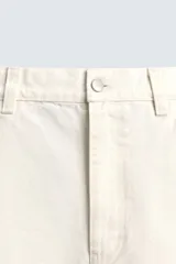 Bermuda de denim color crudo o blanco roto, de corte ancho (baggy fit) y largo hasta la rodilla. Presenta cinco bolsillos, bordado a tono en el frente y un parche con logo en la parte trasera.
