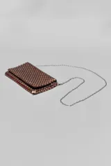Bandolera pequeña de malla metálica en color cobre, con solapa frontal y cadena larga plateada para llevar al hombro o cruzada.