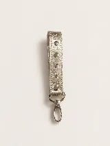 Llavero de muñeca confeccionado en cuero con acabado metalizado dorado y detalle de tachas metálicas circulares. Incluye un gancho de mosquetón plateado para sujetar las llaves.