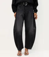 Pantalón baggy balloon de jean negro, tiro medio, con calce amplio, recortes estructurales y botamanga ajustada. Incluye bolsillos delanteros y traseros, y un cinturón de PU negro con hebilla metálica circular.