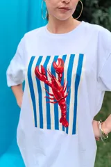 Remerón de algodón blanco con corte oversize y cuello redondo, que presenta un estampado frontal con diseño de una lata de sardinas sobre fondo de rayas.