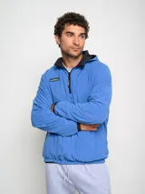 Canguro negro con capucha y medio cierre, marca Umbro, modelo Urban. Detalles en azul en el logo, interior de la capucha y ribete de los bolsillos.