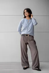 Pantalón de vestir color gris oscuro, de tiro alto y corte palazzo. Presenta una hebilla de metal plateado en el cinturón.