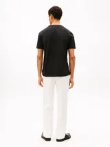 Remera de manga corta Tommy Hilfiger confeccionada en tejido de piqué de algodón. Presenta un diseño de corte regular con cuello redondo acentuado por ribetes tricolores y un bolsillo de parche en el pecho.