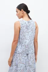 Blusa celeste con estampa floral, sin mangas.