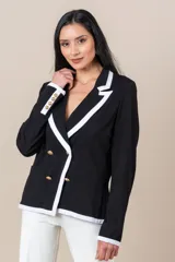 Blazer cruzado negro con vivos blancos en solapas y bolsillos, botones dorados frontales y en puños.